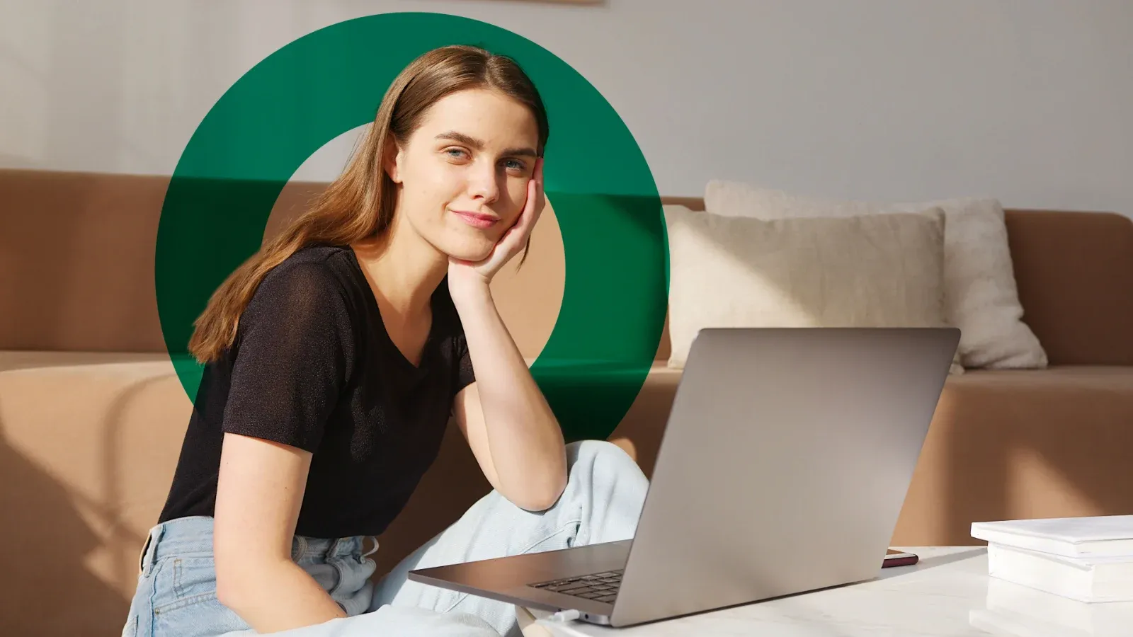 A woman sitting at a laptop at home, resting her chin on her hand
